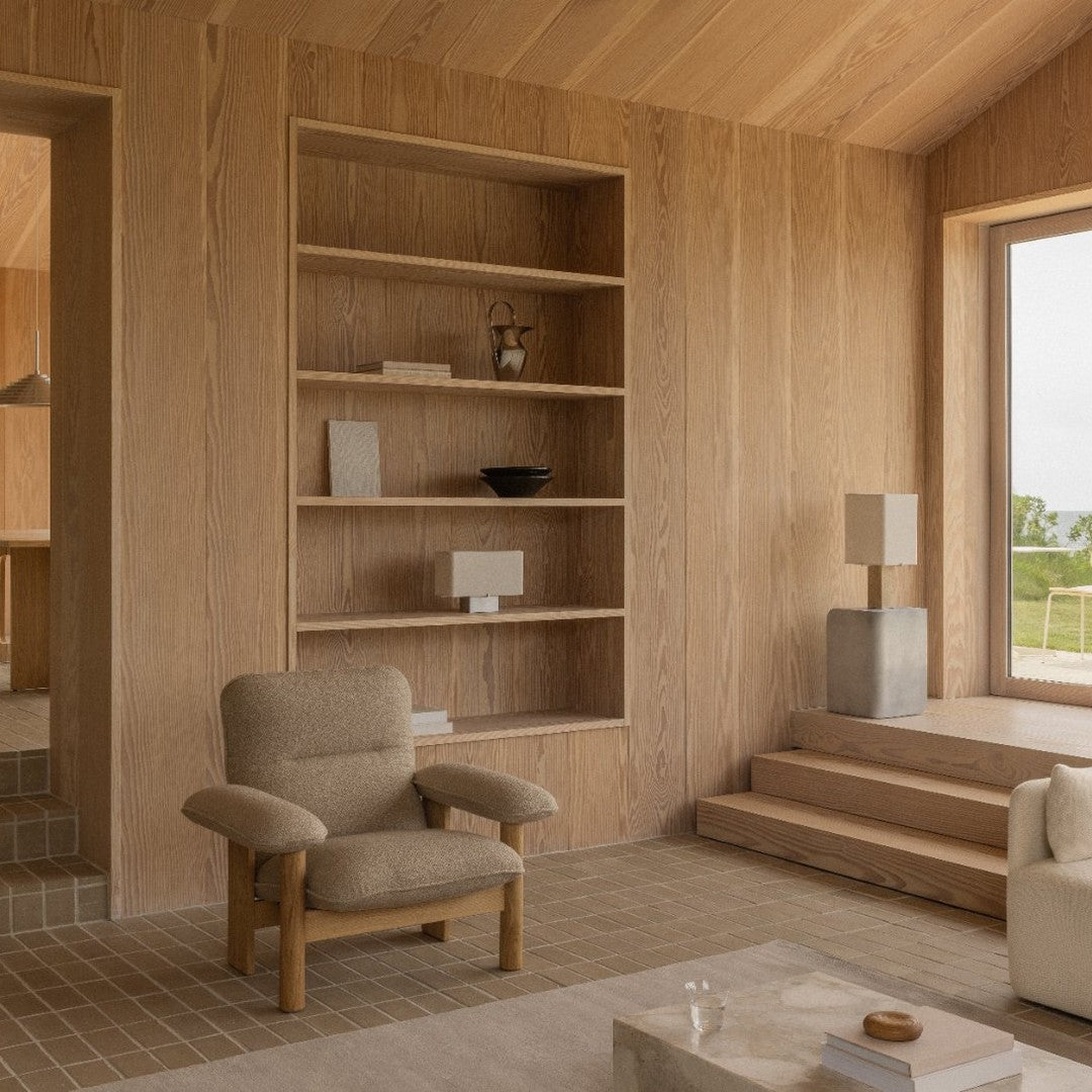 Minimalist interior with beige tones, textured patterns, natural wood shelves, and soft neutral furnishings.