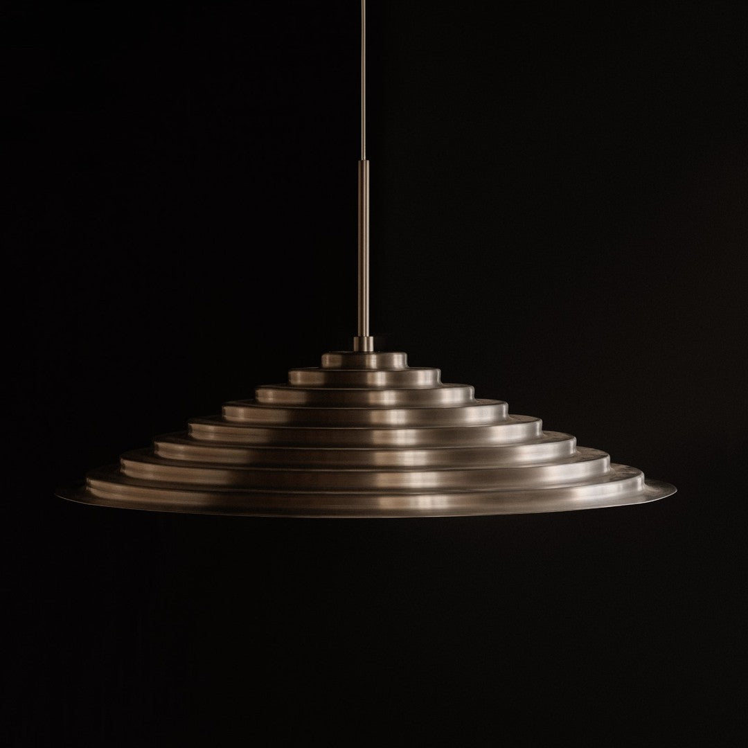 Sleek metallic pendant lamp featuring a layered, conical design with a polished finish. Ideal for modern interiors.