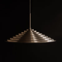 Sleek metallic pendant lamp featuring a layered, conical design with a polished finish. Ideal for modern interiors.