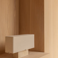 Light beige rectangular lamp on a natural wood shelf, showcasing a minimalist design and warm tones.