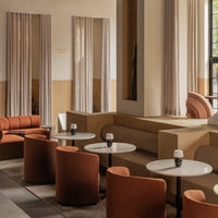 Rust-colored seating and soft beige accents create a cozy, modern atmosphere in this stylish café interior.