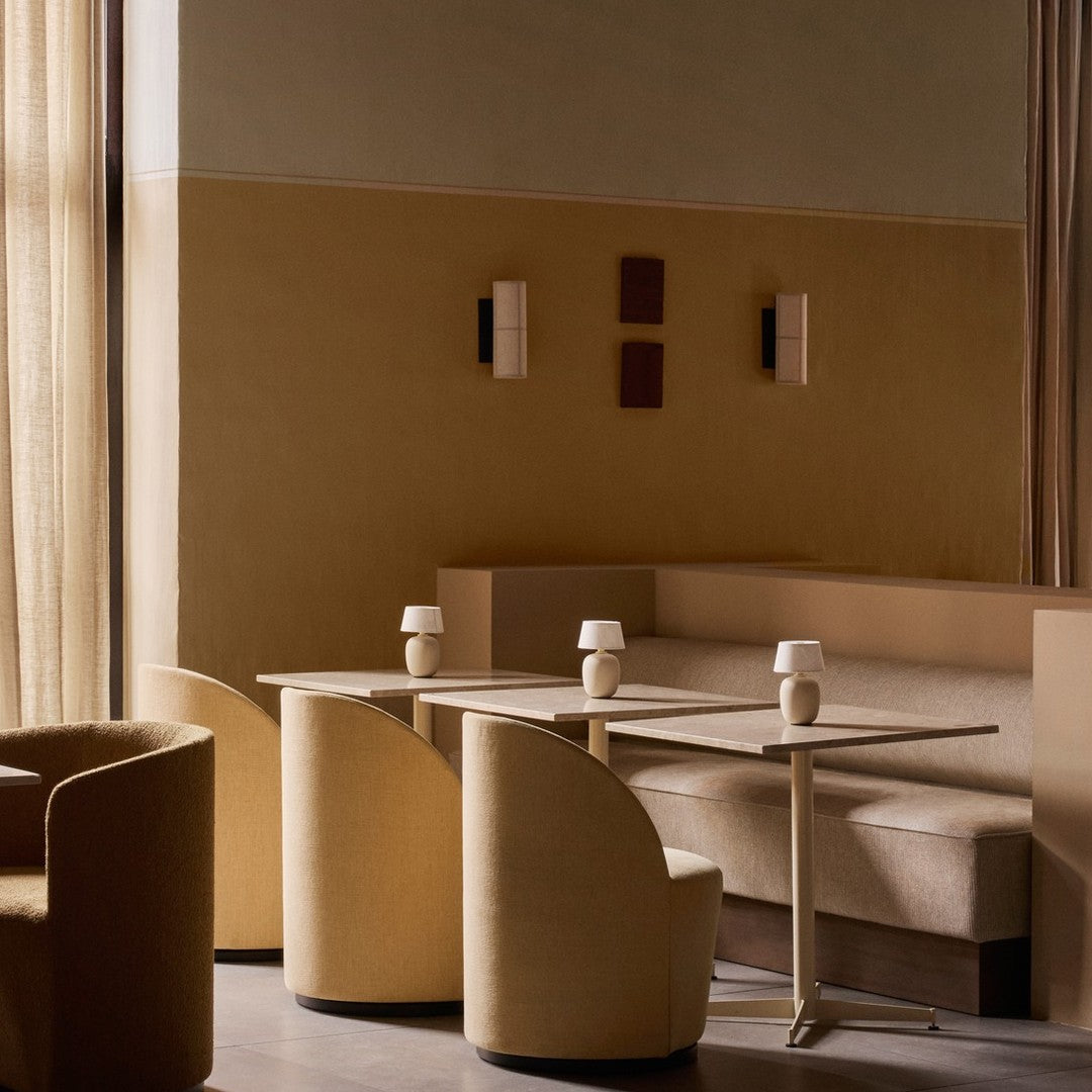 Neutral shades of beige and soft cream create a modern, minimalist dining area with smooth, round furniture.