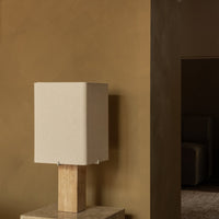 Beige square lamp with a natural wood base, set against a warm, earthy brown wall. Elegant and minimalist design.
