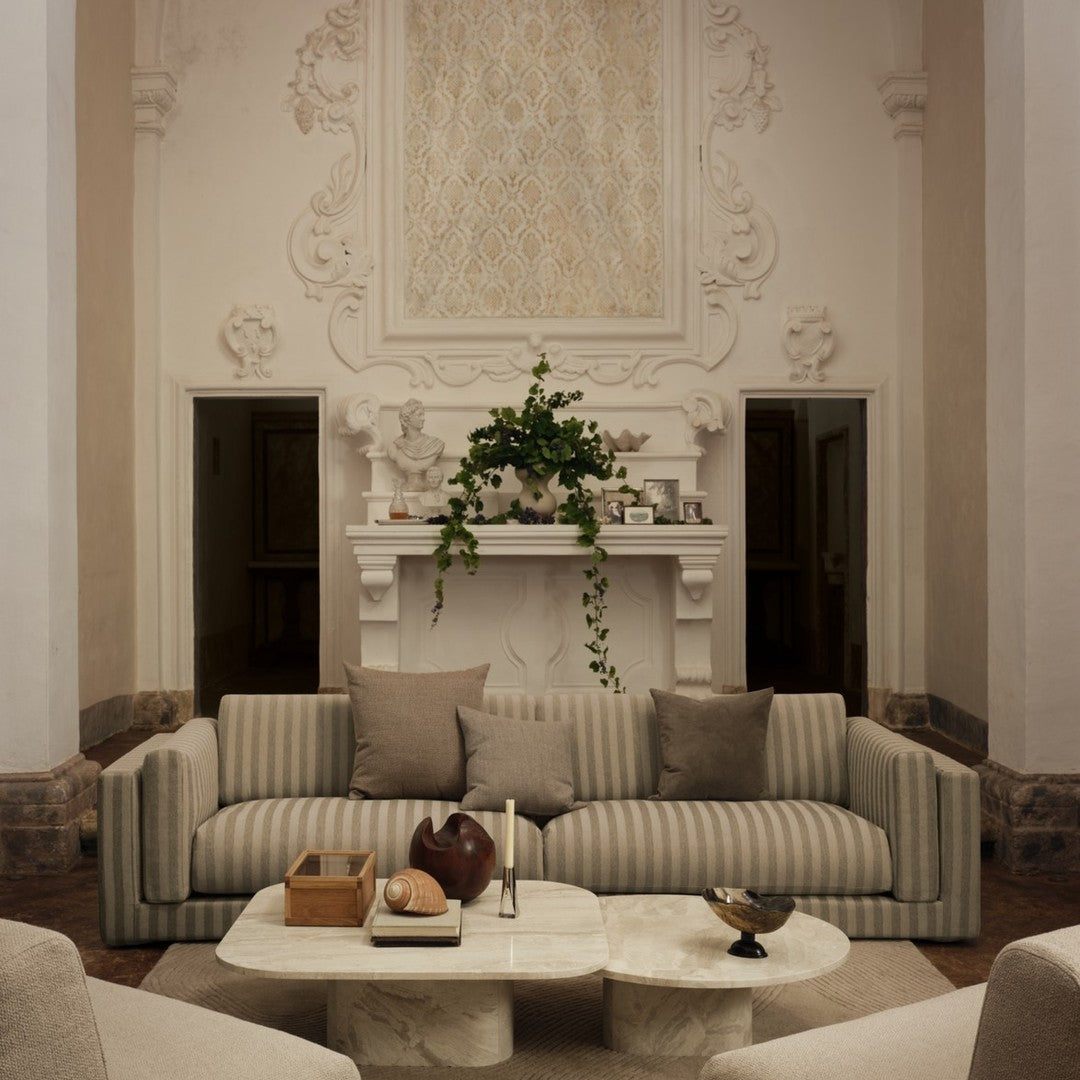 Beige striped sofa with soft gray cushions in a modern living room setting, complemented by a marble coffee table.