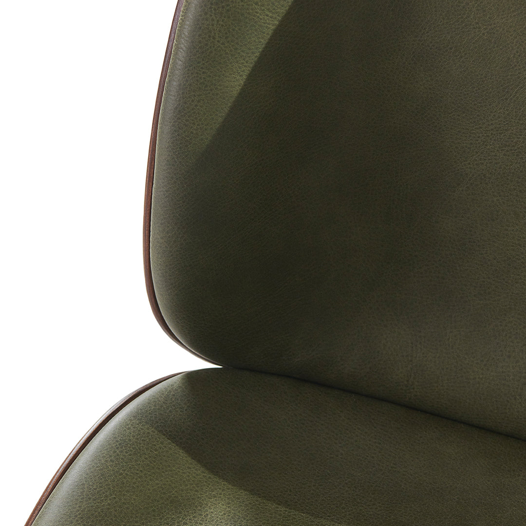 "Close-up of olive green chair upholstery with smooth texture and subtle sheen, accented by a brown trim."