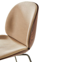 Beige upholstered chair with a smooth finish and walnut wood accents, featuring a minimalist design.