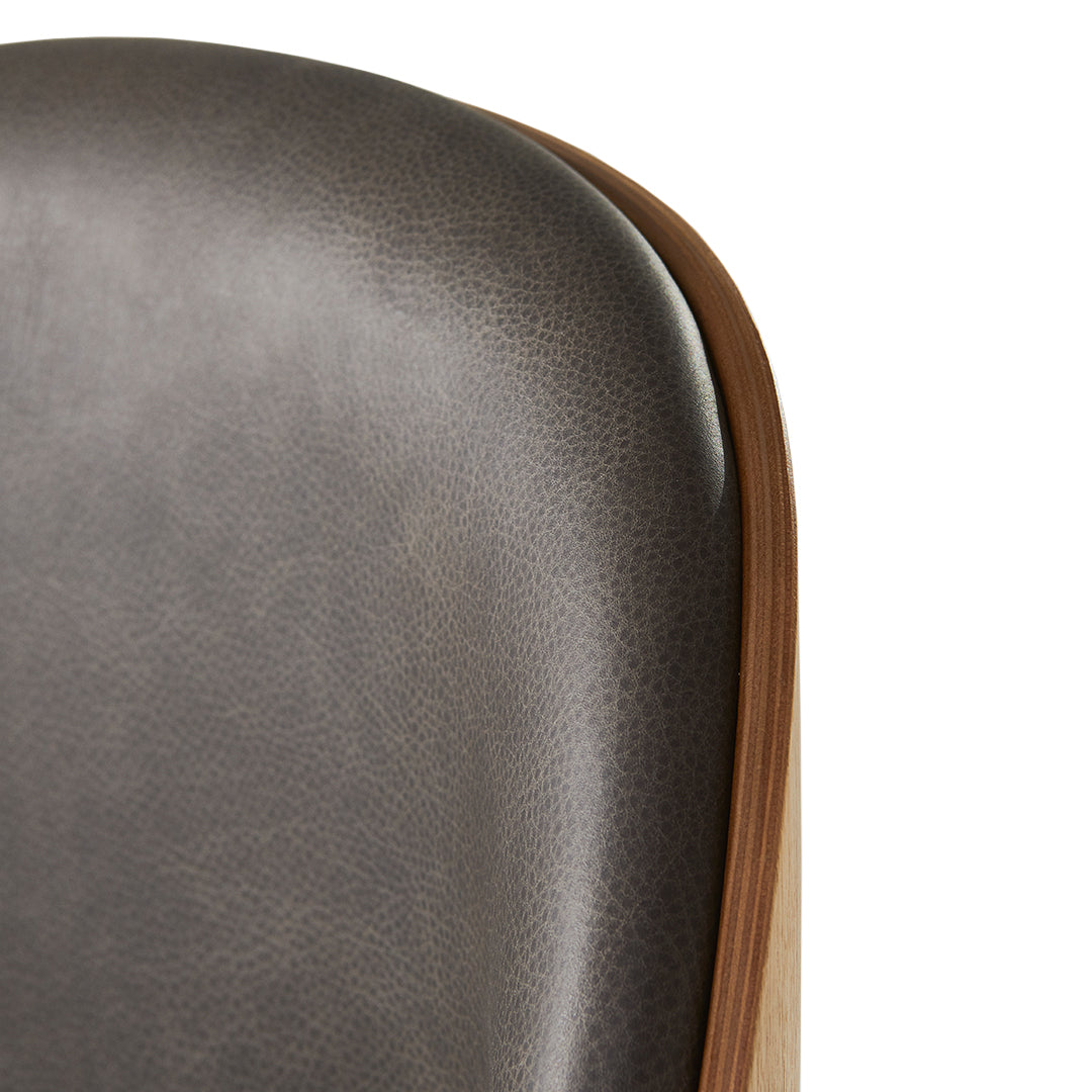 Stylish gray leather chair back with smooth texture and warm wood accent. Modern design for contemporary interiors.
