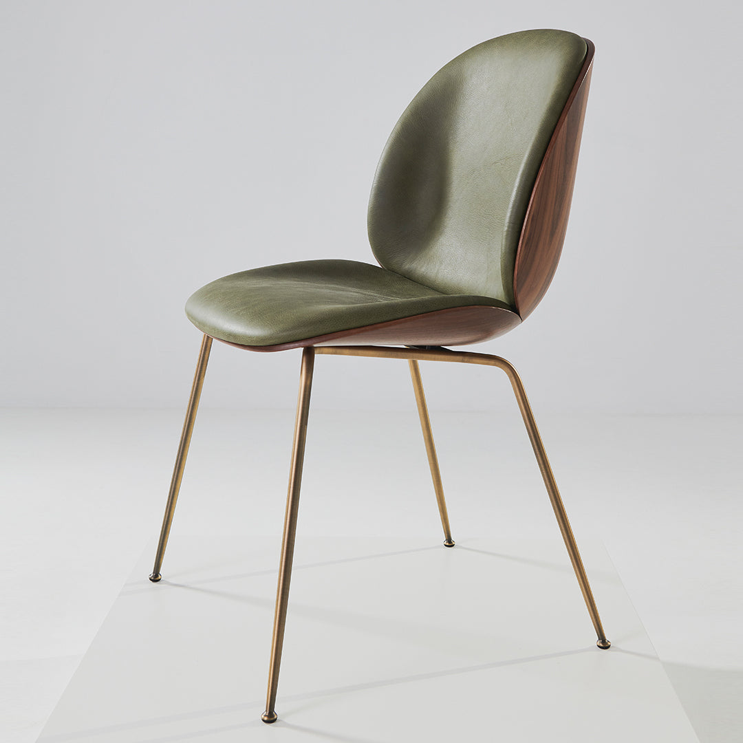 Olive green and brown patterned chair with sleek metal legs, modern design on a light background.