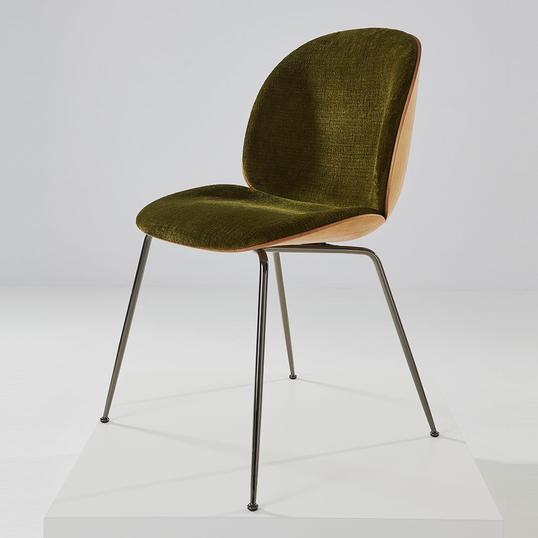 Olive green velvet chair with a wooden backrest and sleek black metal legs, minimalist design.