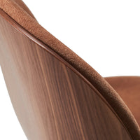Brown upholstered chair with a sleek wooden back, showcasing rich textures and warm, earthy tones.