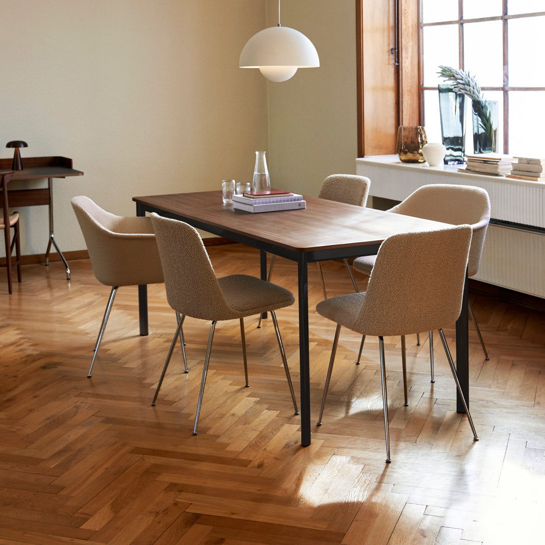 Wooden dining table with beige chairs, set against a warm wooden floor and soft neutral walls. Modern and cozy aesthetic.