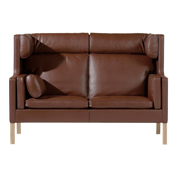 Brown leather sofa with a smooth surface and modern design, featuring simple lines and light wooden legs.