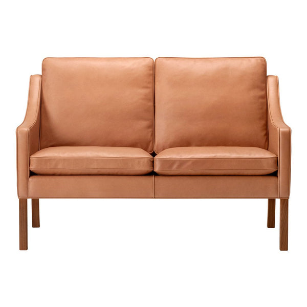 Tan leather loveseat with smooth, minimalist design and natural wooden legs. Perfect for modern interiors.