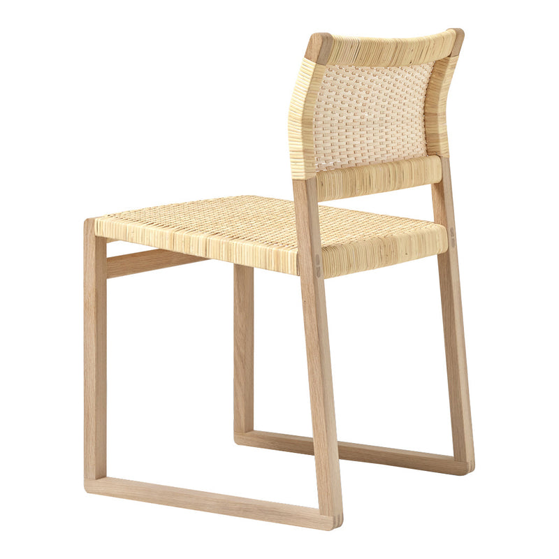 Natural woven rattan chair with light beige tones and smooth wooden frame, showcasing a minimalist design.