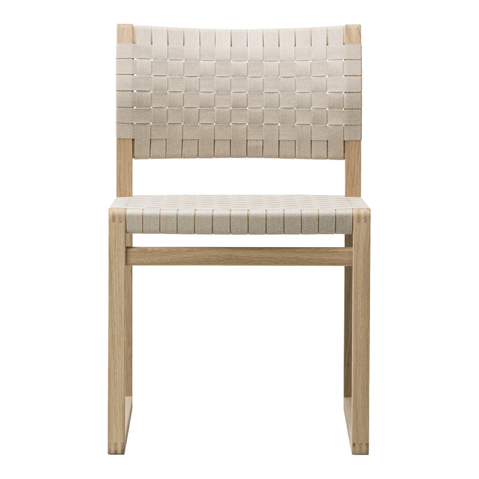 Neutral beige chair with a woven pattern and light wood frame, perfect for minimalist decor.