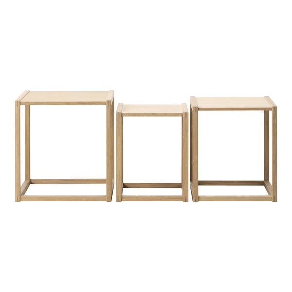 Set of three minimalist nested tables, featuring a natural wood finish in light beige tones with clean lines.