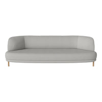 Light gray curved sofa with minimalistic design and wooden legs, featuring a solid color pattern.