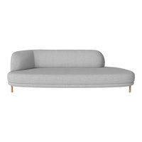 Light gray curved sofa with smooth fabric and minimalist design, complemented by wooden legs.