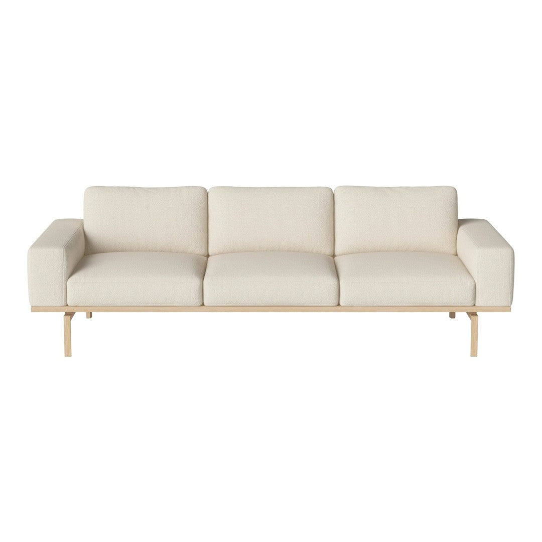 Light beige three-seater sofa with a minimalist design and smooth fabric, featuring a sleek wooden base.