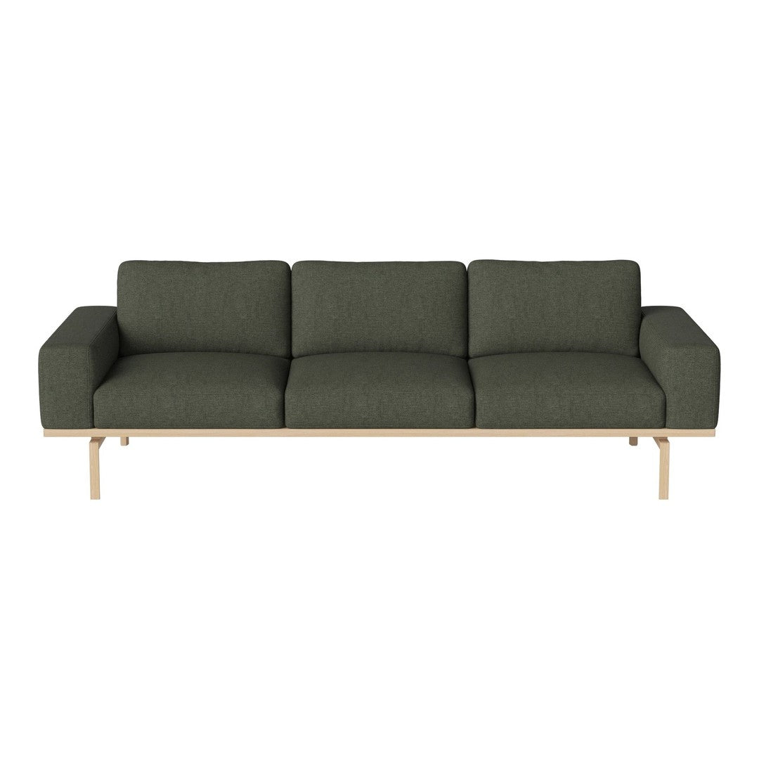 Sleek modern sofa in deep green fabric with a light wood base, featuring a minimalist design and clean lines.