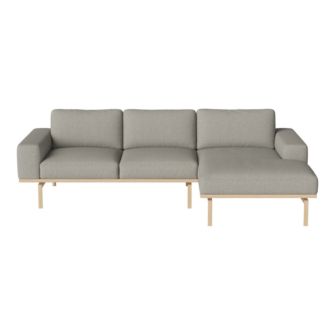 Modern gray sectional sofa with a minimalist design and light wood legs, featuring a smooth, textured fabric.