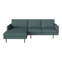 Teal upholstered sectional sofa with sleek lines and minimalist design, featuring a bold, solid color and modern appeal.