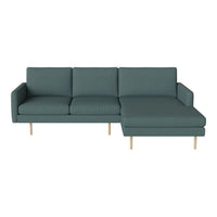 Teal sectional sofa with a modern design and simple, clean lines; features light wooden legs for a contemporary touch.