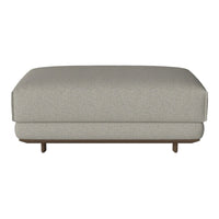 Light gray upholstered ottoman with subtle textures and clean lines, featuring a natural wood base.