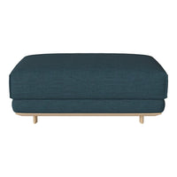 Teal upholstered ottoman with a simple, modern design and light wood legs, adding a pop of color to any space.