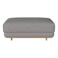 Gray upholstered ottoman with a smooth texture and wooden legs, featuring a minimalist design.
