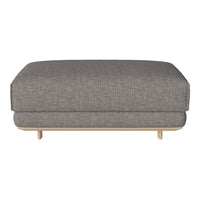 Gray upholstered ottoman with a sleek, textured pattern and wooden legs. Perfect for modern living spaces.