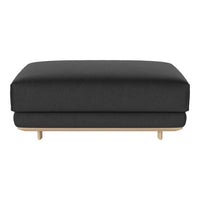 Black upholstered ottoman with a smooth texture and natural wood base. Minimalist design for modern interiors.
