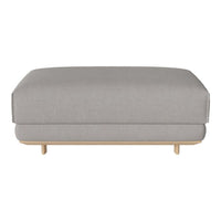 Gray upholstered ottoman with a smooth texture and minimalist design, featuring light wooden legs.