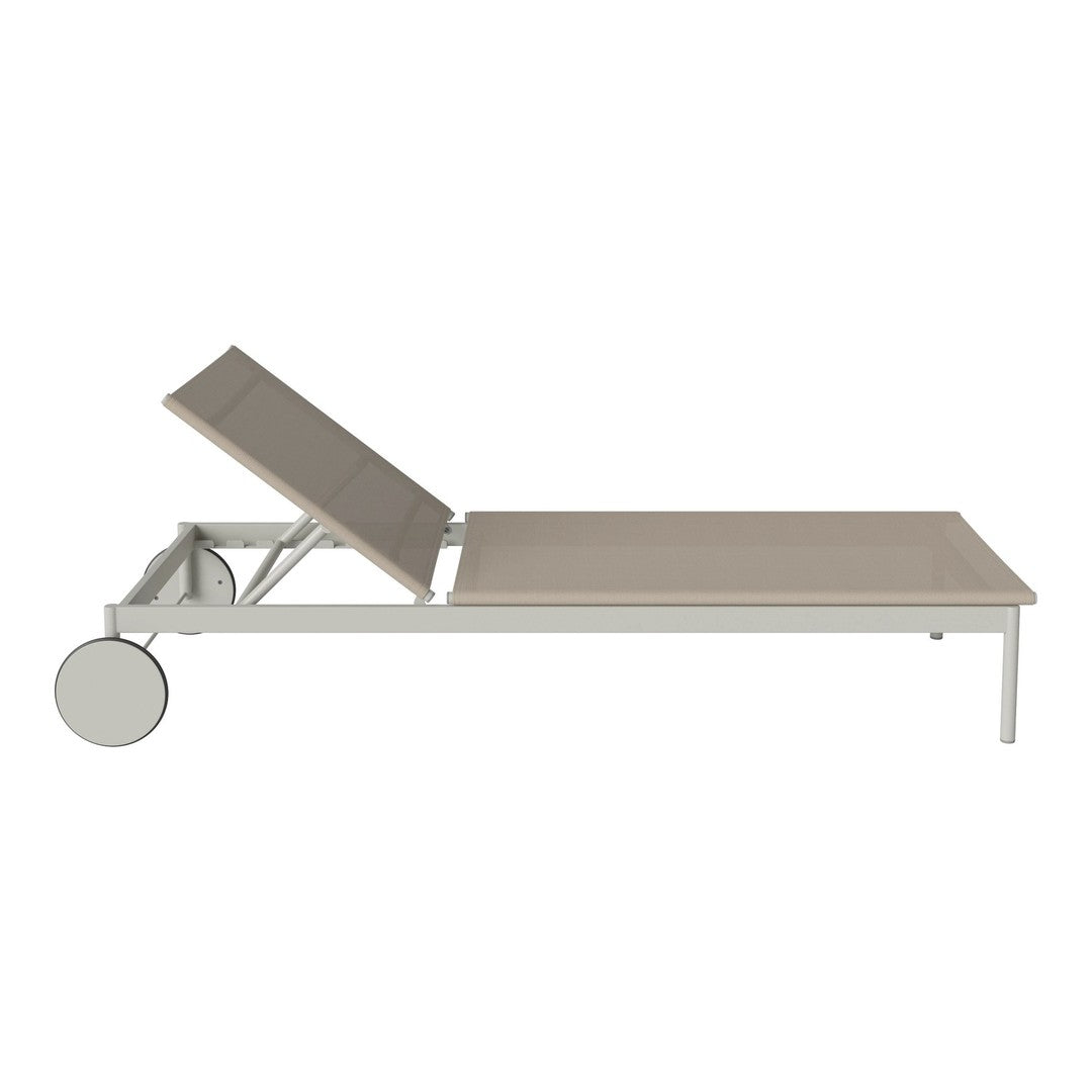 Light beige lounging chair with a sleek white frame, featuring a minimalist design and a smooth, flat surface.