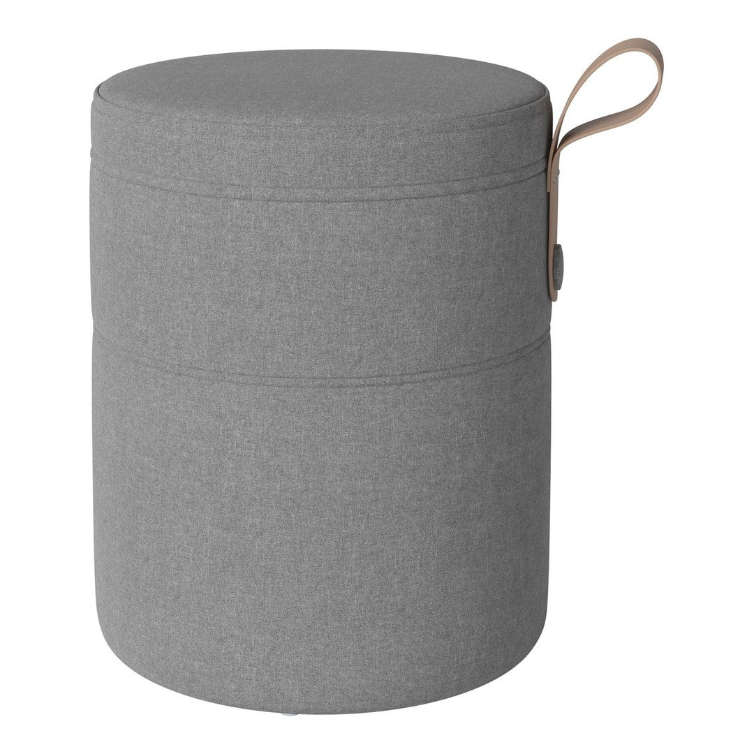 Round gray storage ottoman with a smooth texture and minimalist design, featuring a tan handle for easy carrying.