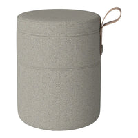 Light gray cylindrical storage ottoman with a textured pattern and a leather handle. Modern and minimalist design.