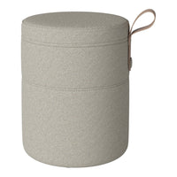 Light gray cylindrical storage ottoman with a textured pattern and a tan leather handle.