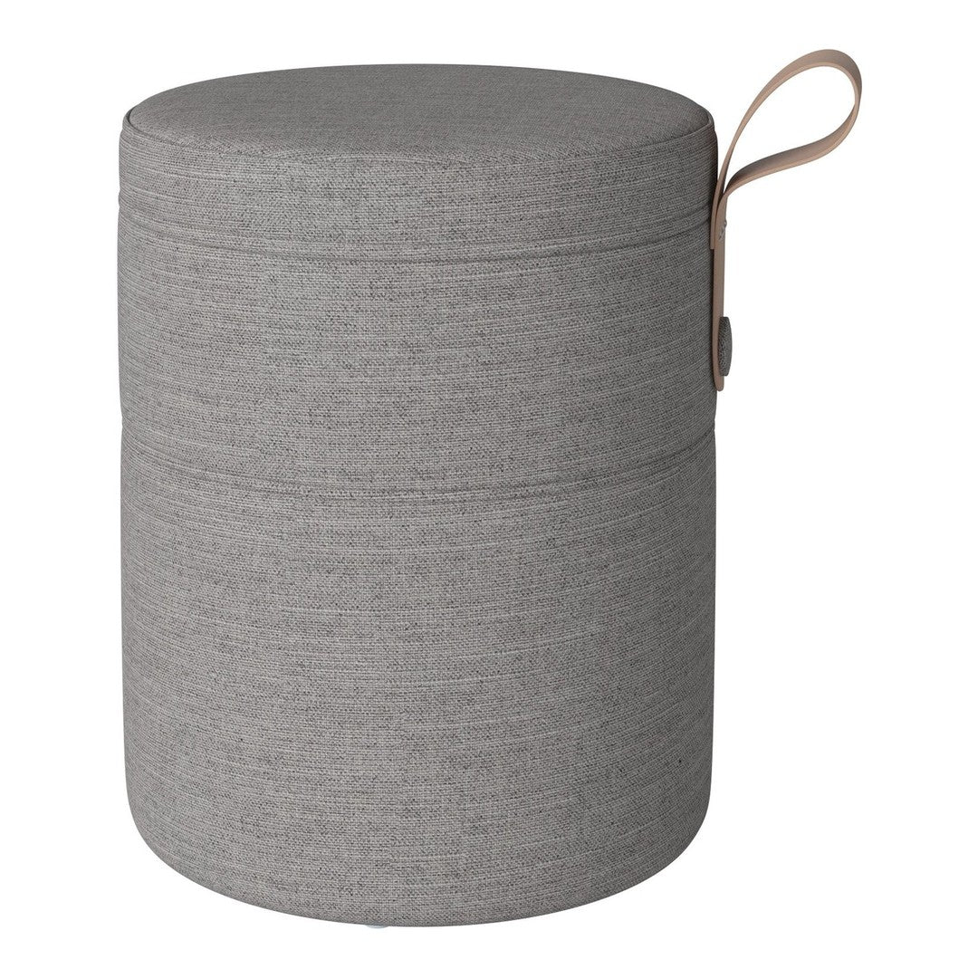 Gray fabric storage ottoman with a smooth texture and subtle horizontal patterns, featuring a brown handle.