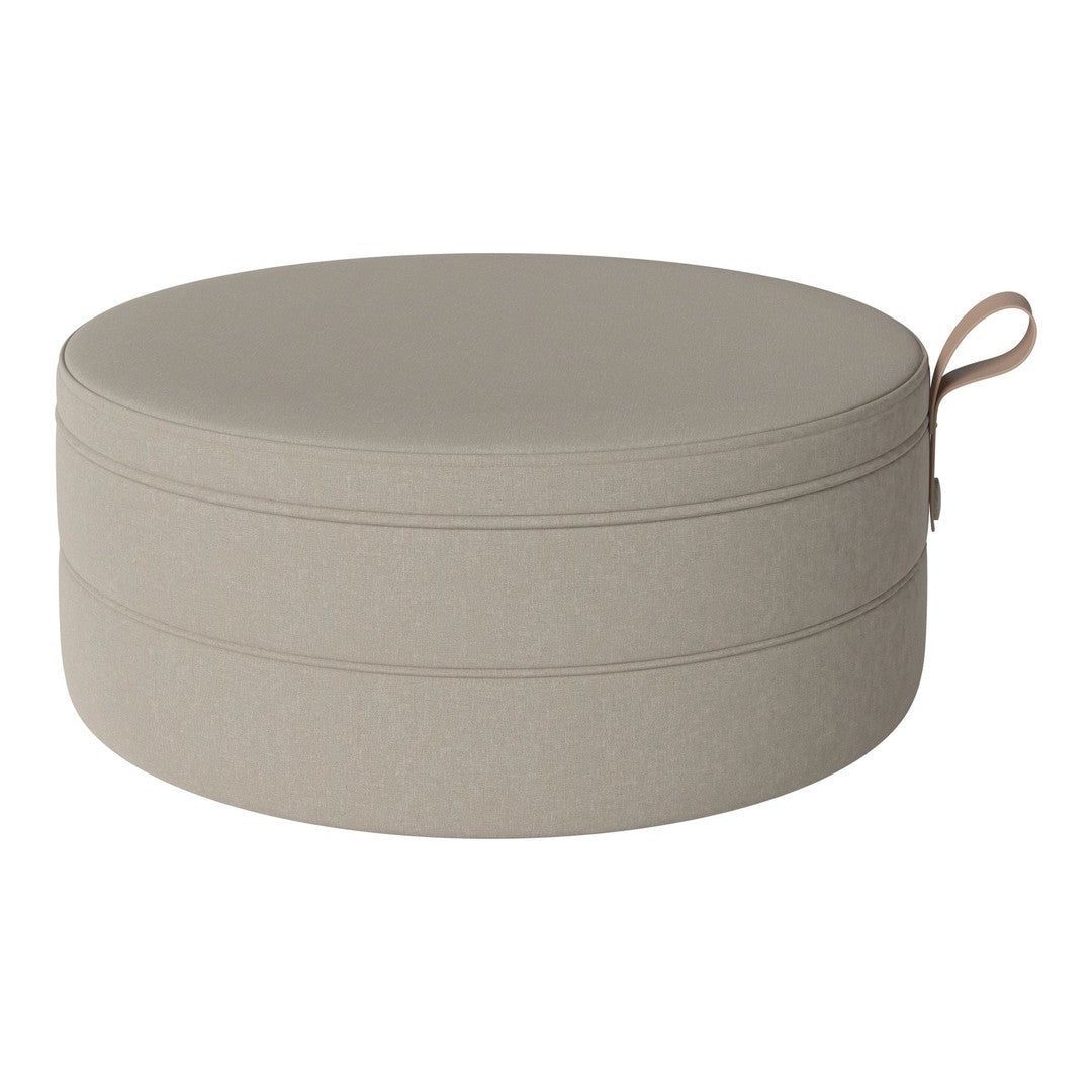 Round beige storage ottoman with simple, smooth texture and subtle stitching detail. Ideal for any decor.
