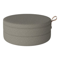 Round gray storage ottoman with a smooth texture and minimalistic design, featuring a stylish handle.