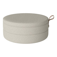 Round storage ottoman in soft beige fabric with subtle texture and a stylish handle for easy mobility.