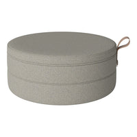Round grey pouf with a smooth texture and subtle pattern, featuring a convenient leather handle for easy carrying.