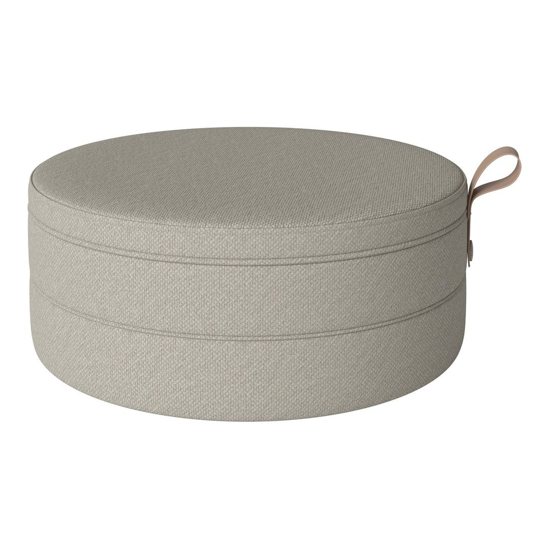 Light gray textured round pouf with a subtle stitched pattern and a convenient handle. Ideal for modern decor.