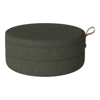 Round green fabric pouf with a textured pattern and a side handle. Ideal for modern decor.