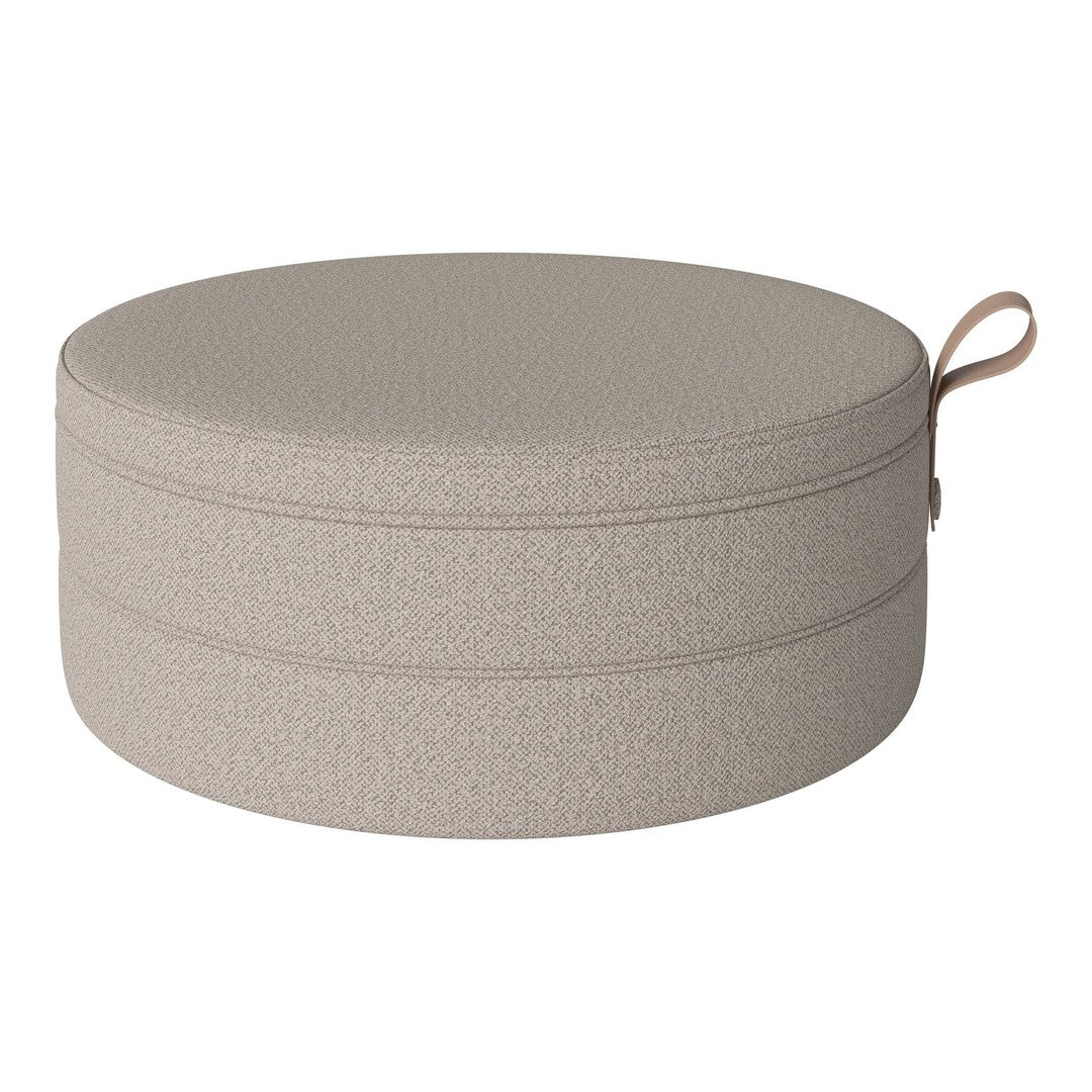 Round beige storage ottoman with a textured pattern and a convenient handle for easy carrying.