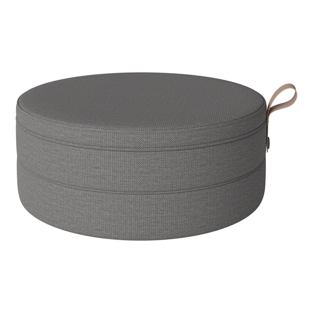 Round gray storage pouf with a textured pattern and a convenient beige handle. Perfect for modern decor.