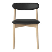 "Minimalist black chair with smooth leather seat and light wooden legs, showcasing a sleek, modern design."