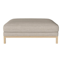 Beige upholstered ottoman with a clean, minimalist design and light wooden legs. Ideal for modern decor.