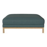 Teal upholstered ottoman with subtle texture and light wood legs, perfect for contemporary decor.