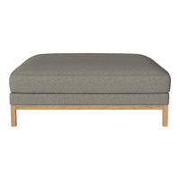 Gray upholstered ottoman with a smooth finish and a light wood base. Minimalist design perfect for modern decor.